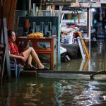 ホーチミン市内で家屋が浸水して呆然とする女性