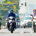 9月末に38℃超えを記録したハノイ市内の道路を走るバイク